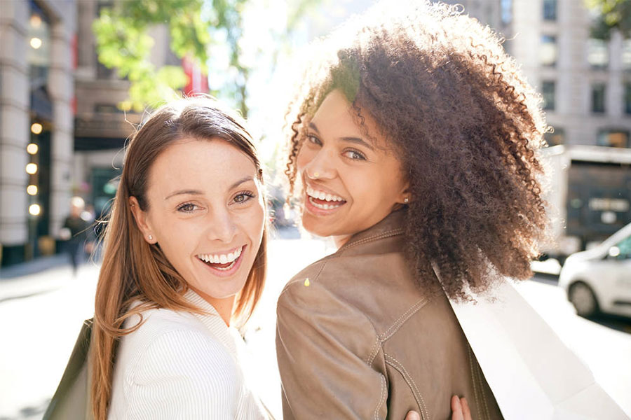 Two smiling women looking behind