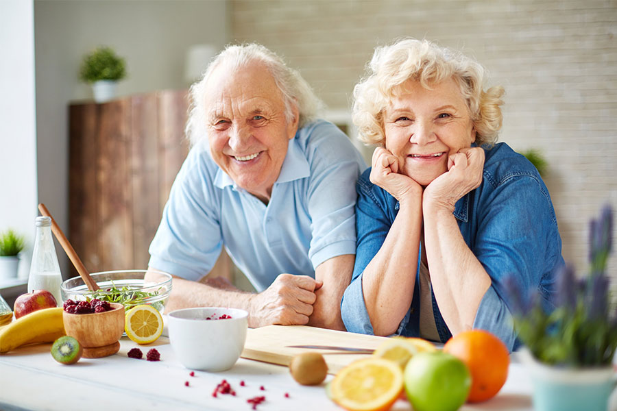 Smiling old couple by the kitchen counter